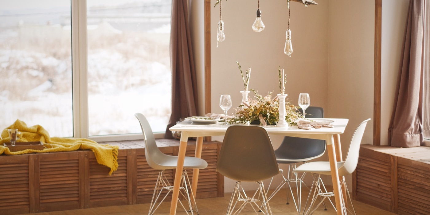 A sunlit dining nook set for guests with a view of snowy peaks