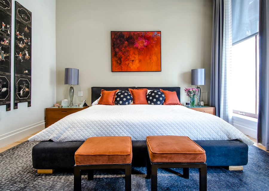 A hotel-crisp bedroom with white bedding, rust accent pillows and a bold art print