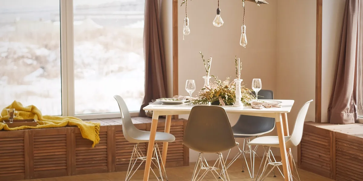 A sunlit dining nook set for guests with a view of snowy peaks
